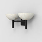 The Clérachic Weft sconce in black, three-quarter view showing the two upright posts under each alabaster bowl.