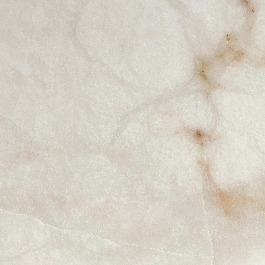 Close detail of the alabaster used on the Clérachic Weft sconce, warm russet veining running through pale stone.
