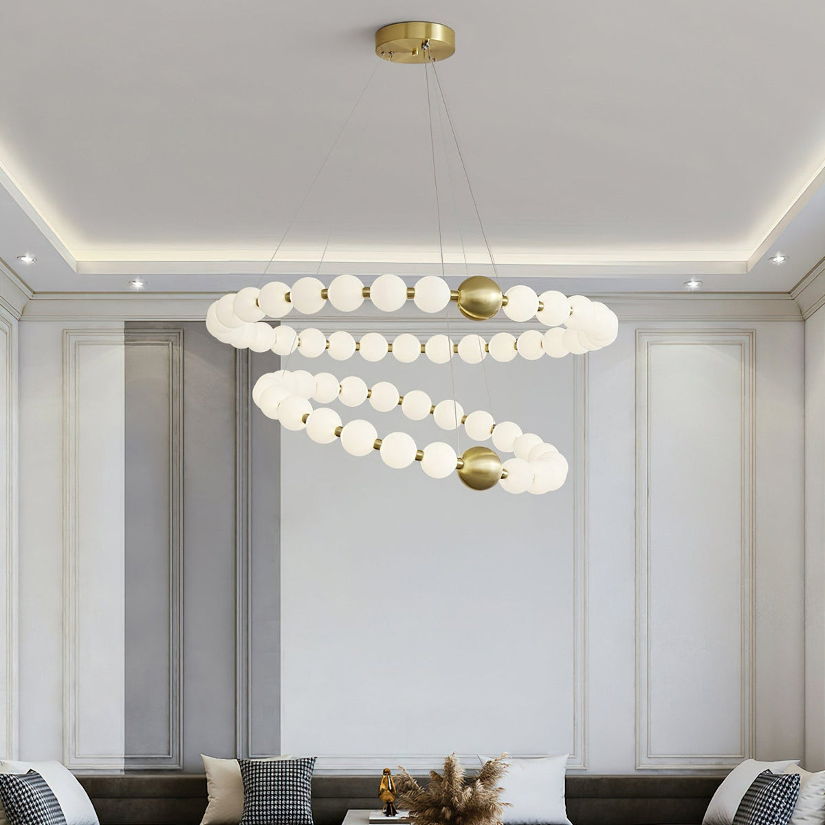 Hung in a panelled living room with a cove-lit ceiling, this Clérachic chandelier shows two rings of white globes above a sofa.