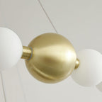 Close view of the large brushed-brass sphere that joins the globe strands on this Clérachic chandelier.