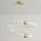 The same Clérachic chandelier unlit, showing its white globes in two spiralling rings under a brass ceiling plate.