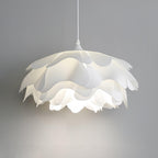 Close, lit view of the scalloped petal edges on this Clérachic pendant against a soft grey wall.