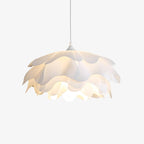 Cut-out view of this Clérachic petal pendant on a pale backdrop, with its tiers of white acrylic lit from within.