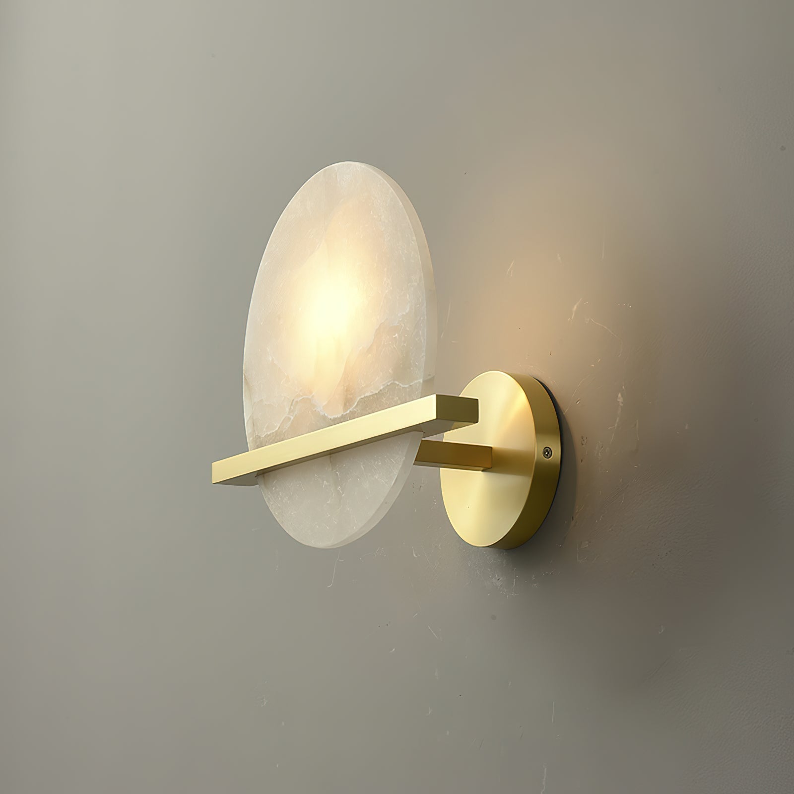 Side profile of the lit Clérachic White Alabaster Wall Sconce, showing how little the brass canopy and disc stand off the wall.