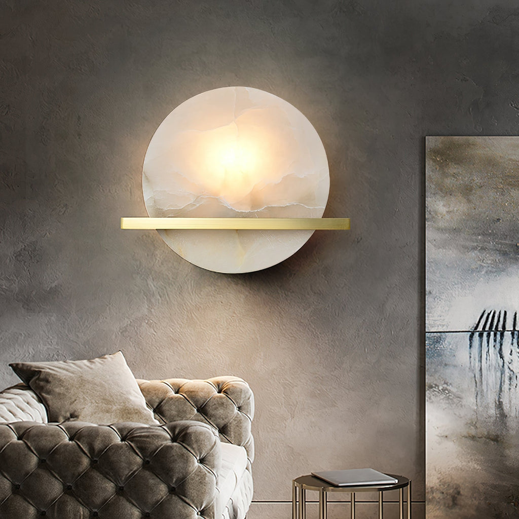 Clérachic White Alabaster Wall Sconce seen straight on in a grey concrete-walled lounge, glowing above a tufted velvet sofa.