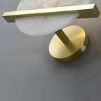 The Clérachic White Alabaster Wall Sconce from above, the brass bar and stem meeting the round canopy on a grey wall.