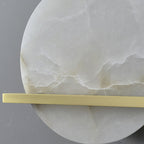 Close crop of the Clérachic White Alabaster Wall Sconce showing the unlit stone's cloudy veining behind the flat brass bar.