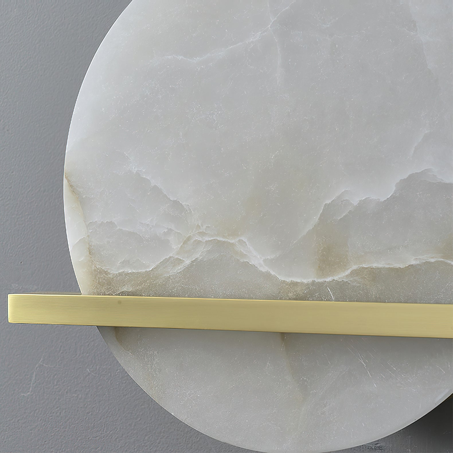 Close crop of the Clérachic White Alabaster Wall Sconce showing the unlit stone's cloudy veining behind the flat brass bar.