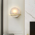 Clérachic White Alabaster Wall Sconce lighting a cream moulded wall panel beside a marble surround in a soft, neutral room.