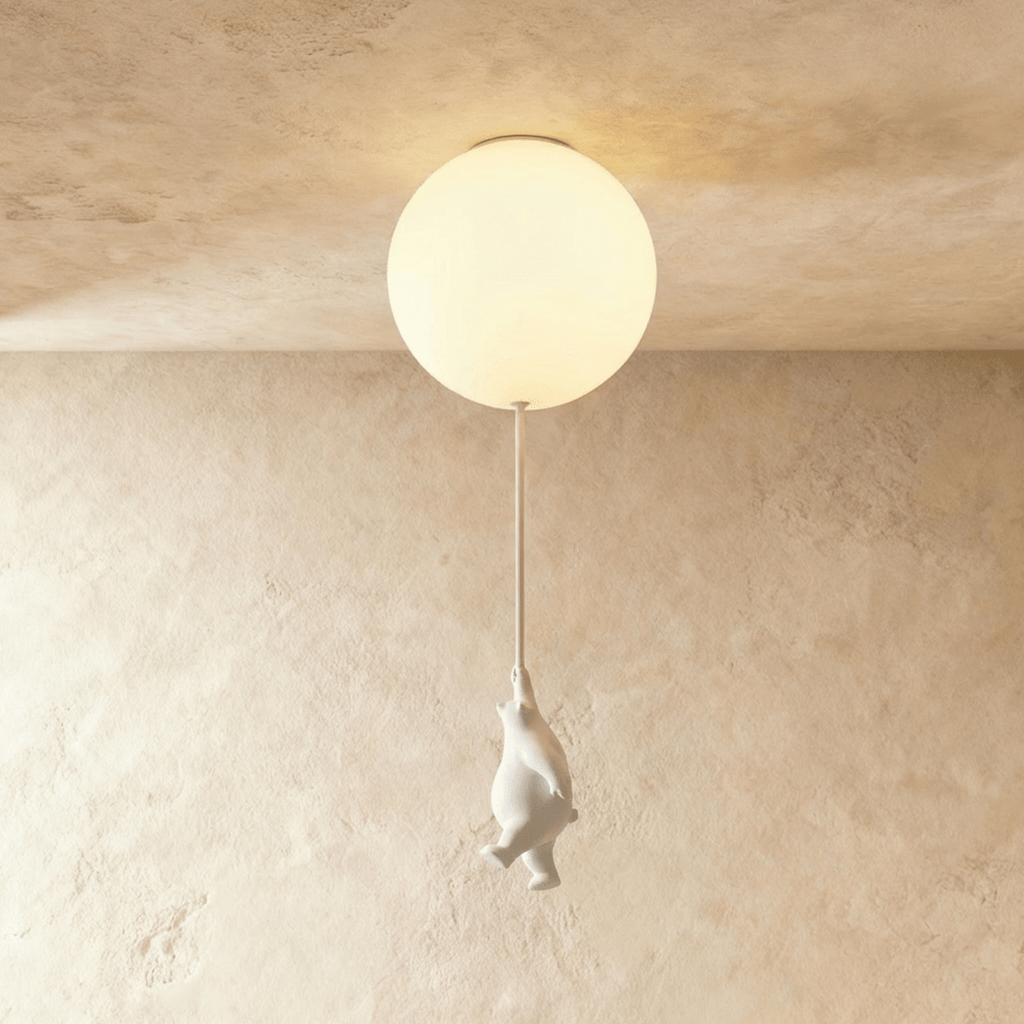Clérachic ceramic bear reaches upward on its cord, suspended just under a glowing frosted glass ceiling globe.