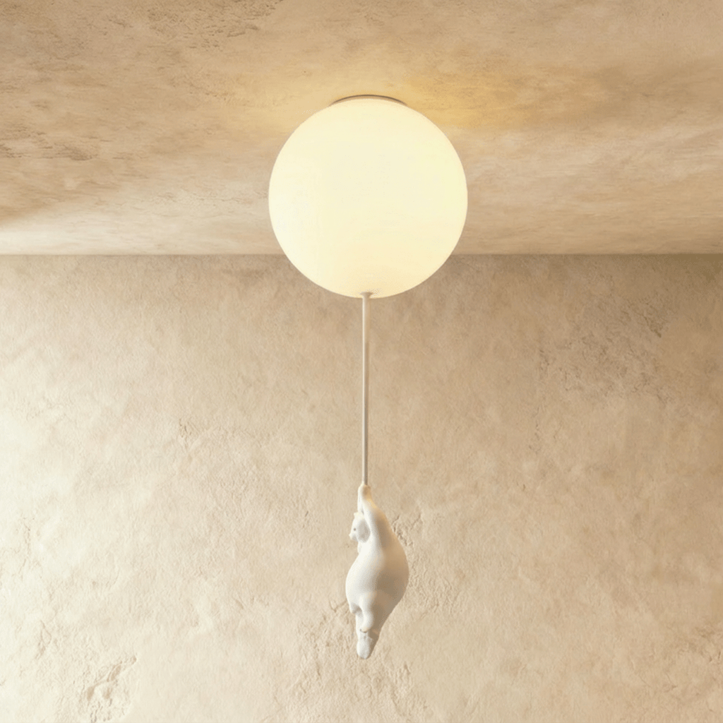 Clérachic bear balloon ceiling light close-up shows a single frosted glass globe glowing above a plaster wall.