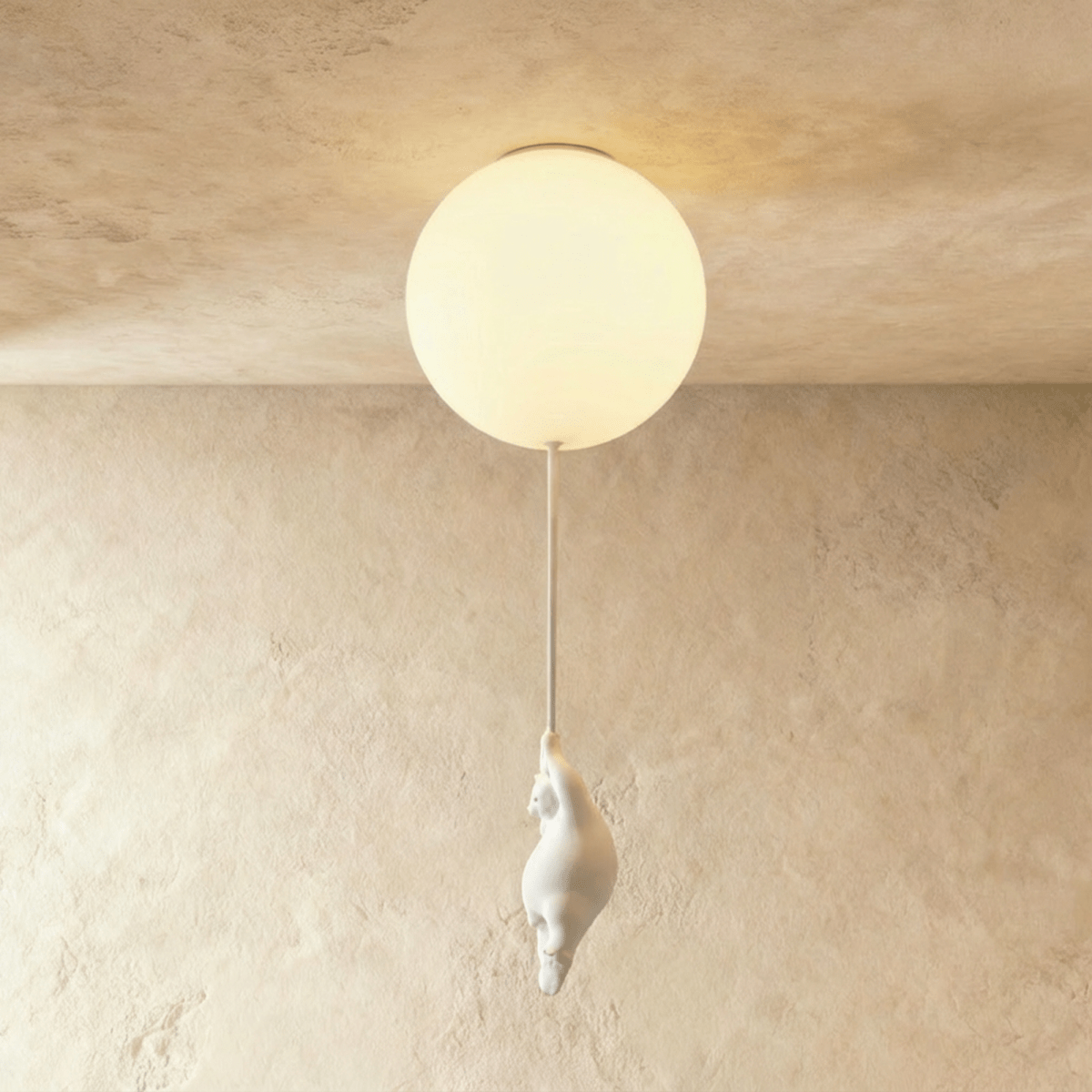 Clérachic bear balloon ceiling light close-up shows a single frosted glass globe glowing above a plaster wall.