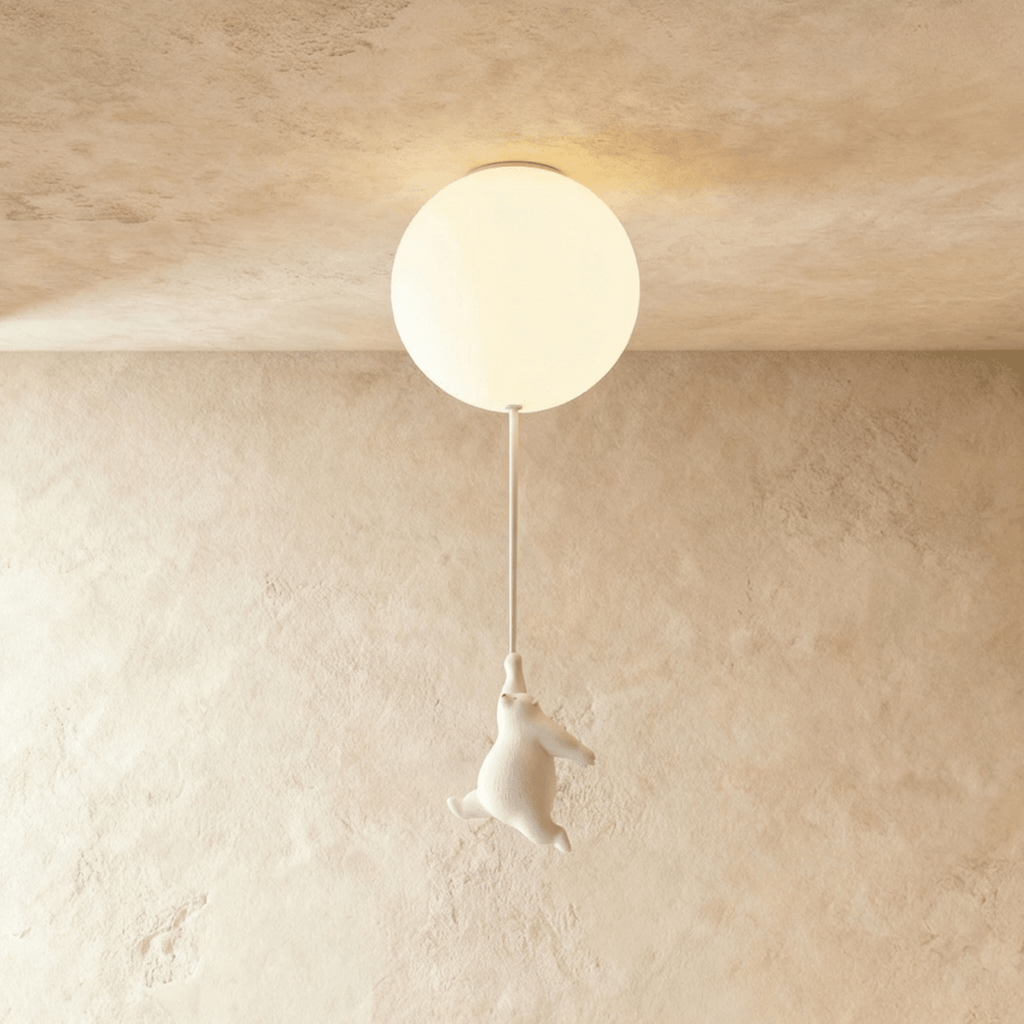 Clérachic white bear figurine hangs by its paws from a cord under a softly lit frosted glass ceiling globe.