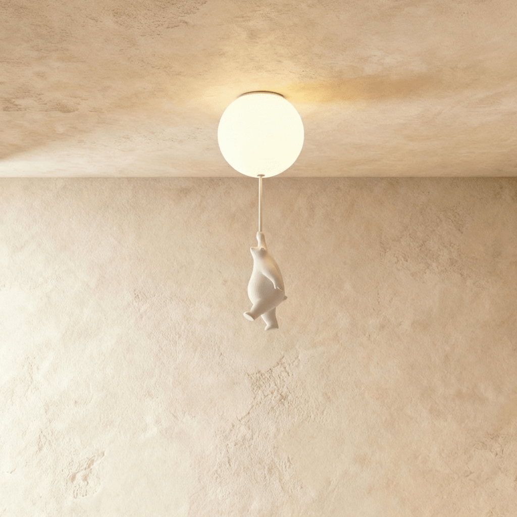Clérachic frosted glass globe ceiling light glows warm with a small white bear figurine hanging from its cord.