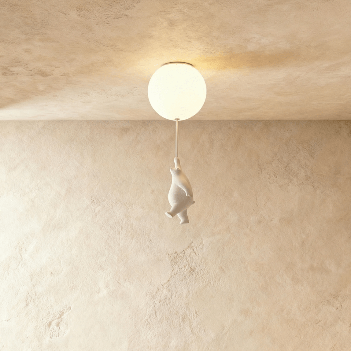 Clérachic frosted glass globe ceiling light glows warm with a small white bear figurine hanging from its cord.
