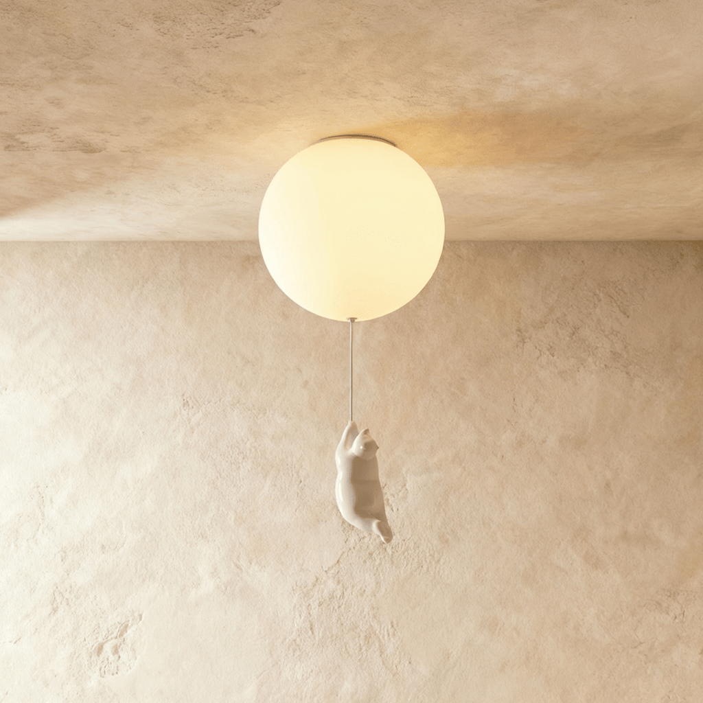 Clérachic ceiling light globe glows softly above a white bear figurine hanging by its front paws on the cord.