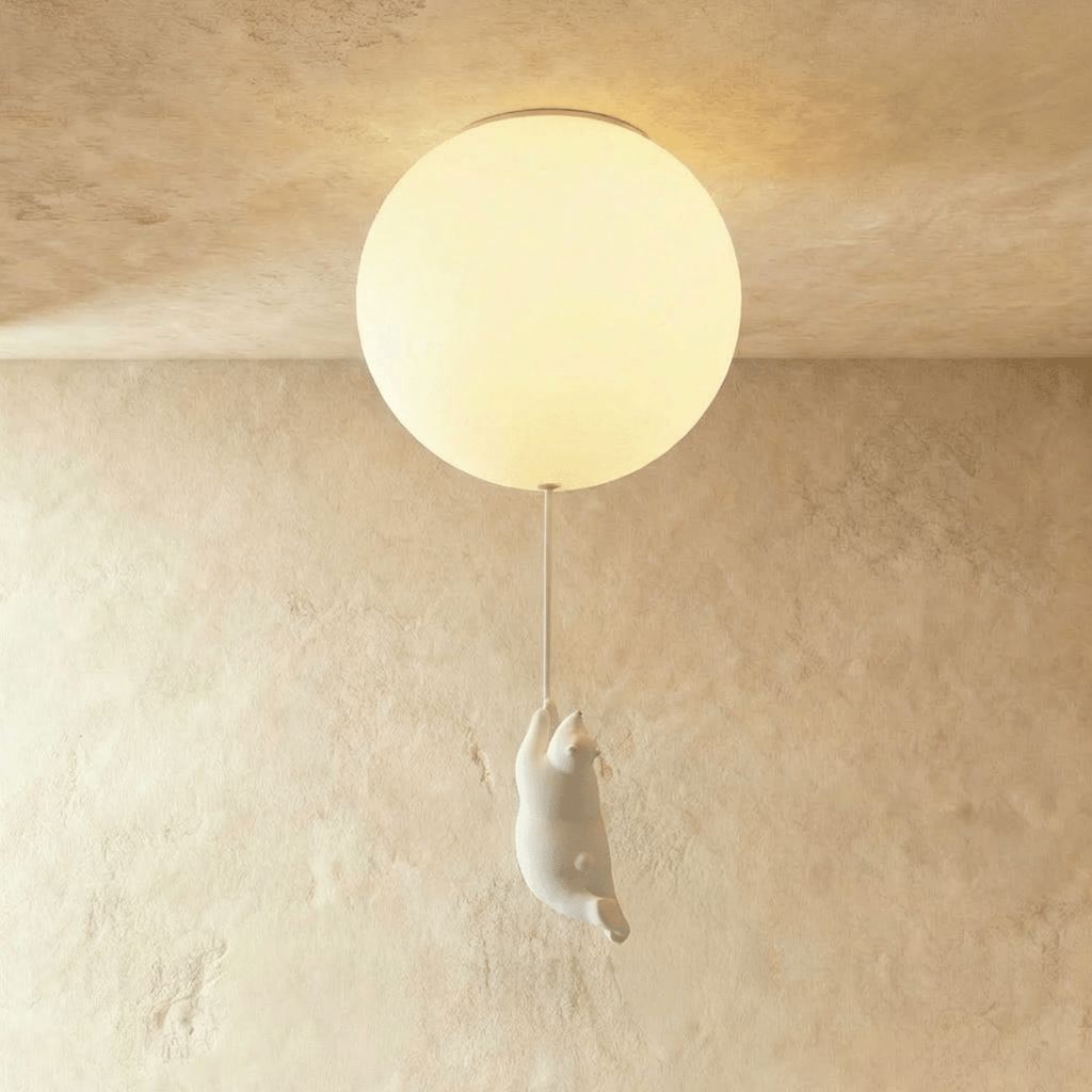 Clérachic single frosted glass globe ceiling light with a bear figurine mid-climb, set on a warm plaster wall.