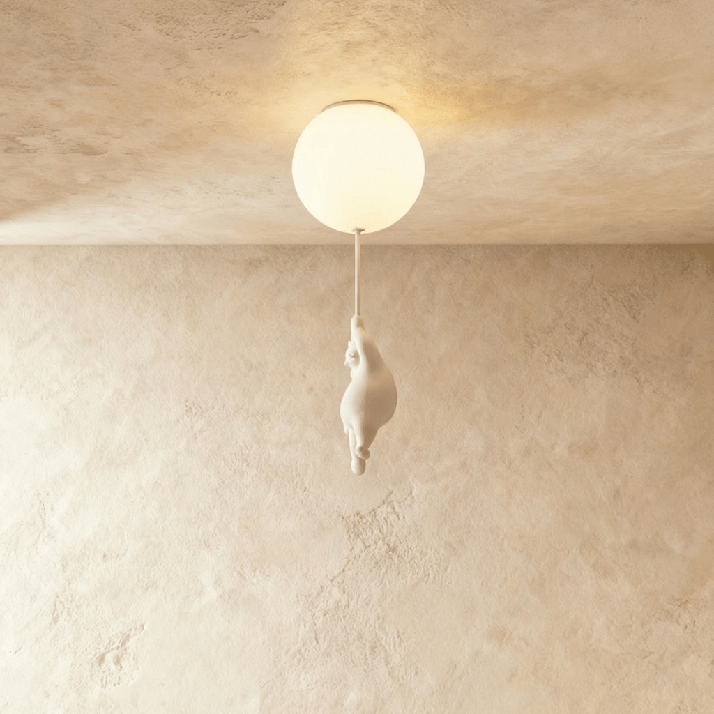 Clérachic bear balloon design close-up shows the figurine climbing under a warm, glowing frosted glass globe.