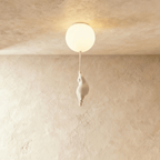 Clérachic bear balloon design close-up shows the figurine climbing under a warm, glowing frosted glass globe.