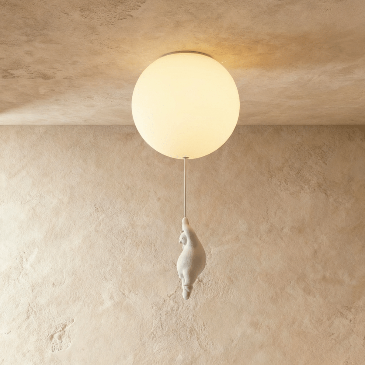 Clérachic flush-mount globe light glows warm with a small bear figurine gripping the cord just below it.
