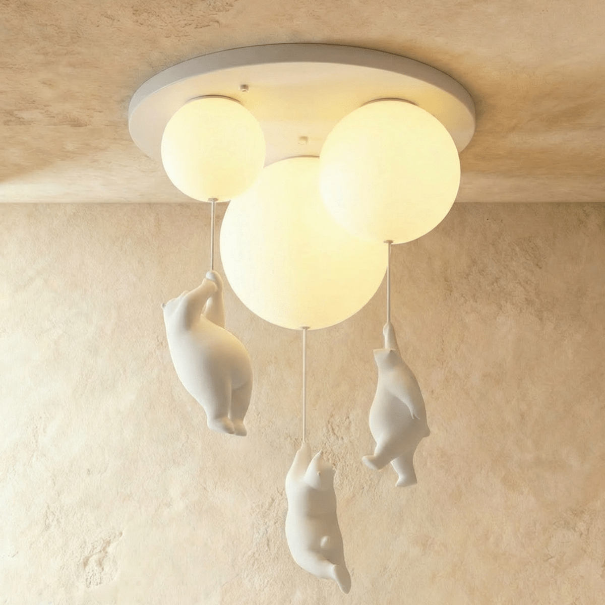 Clérachic three-globe bear balloon ceiling light glows warm, each frosted glass sphere trailing a bear figurine.