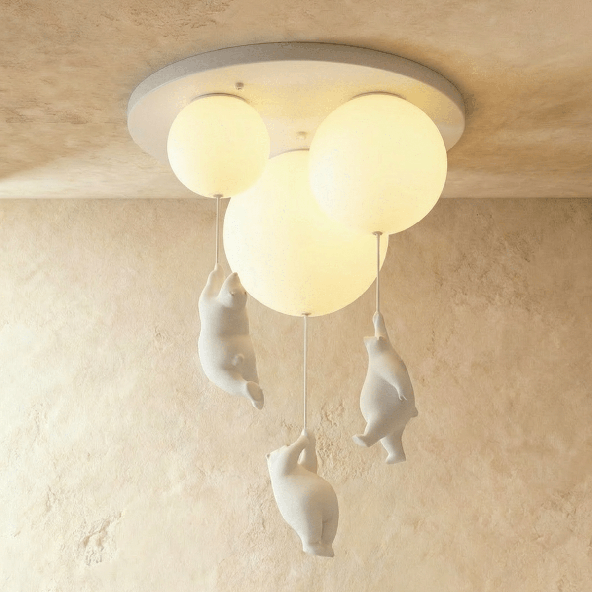 Clérachic three-light bear balloon fixture glows softly, its trio of figurines dangling at different lengths.