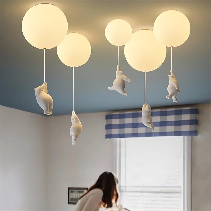 Clérachic bear balloon ceiling lights installed in a child's bedroom, globes glowing warm above a blue ceiling.