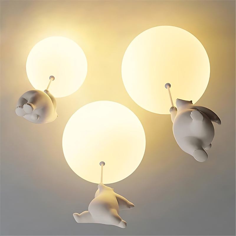Clérachic bear balloon ceiling lights grouped in three sizes, warm globes glowing above climbing figurines.