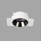 Clérachic trimless downlight housing at an angle, showing the white plaster-in frame and mounting flaps beside the chrome cone.