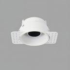 Clérachic trimless downlight with a matte white cone and plaster-in housing, mounting flaps folded out on a gray backdrop.