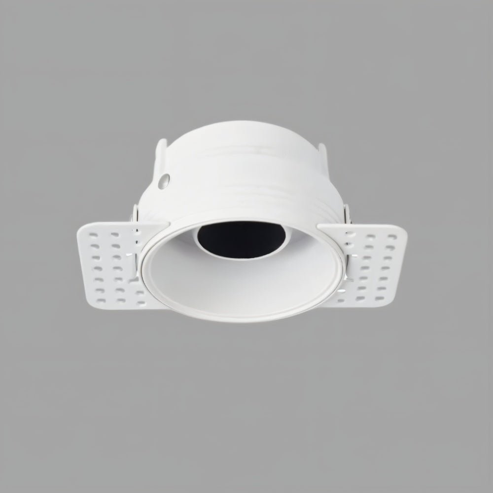Clérachic trimless downlight with a matte white cone and plaster-in housing, mounting flaps folded out on a gray backdrop.
