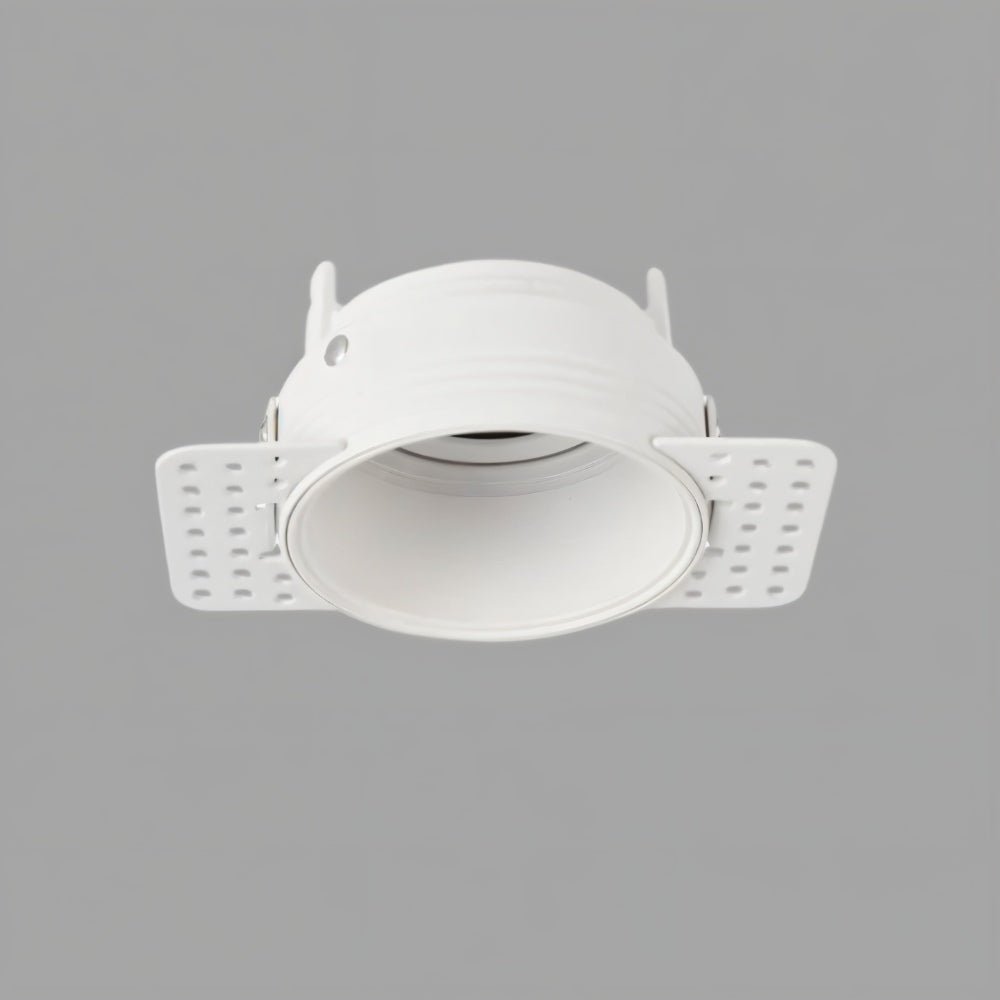 Clérachic trimless downlight shown front-on in white, the smooth cone and plaster-in flanges visible against gray.