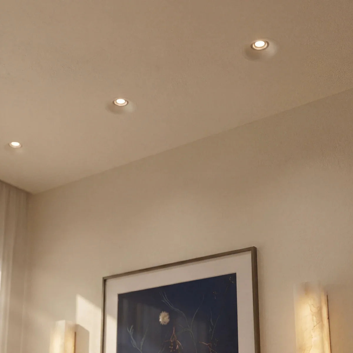 Clérachic trimless recessed downlights set flush into an angled ceiling, glowing softly above a picture frame.