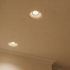 Clérachic trimless recessed downlights in close detail, their flush rings glowing softly against a plaster ceiling.