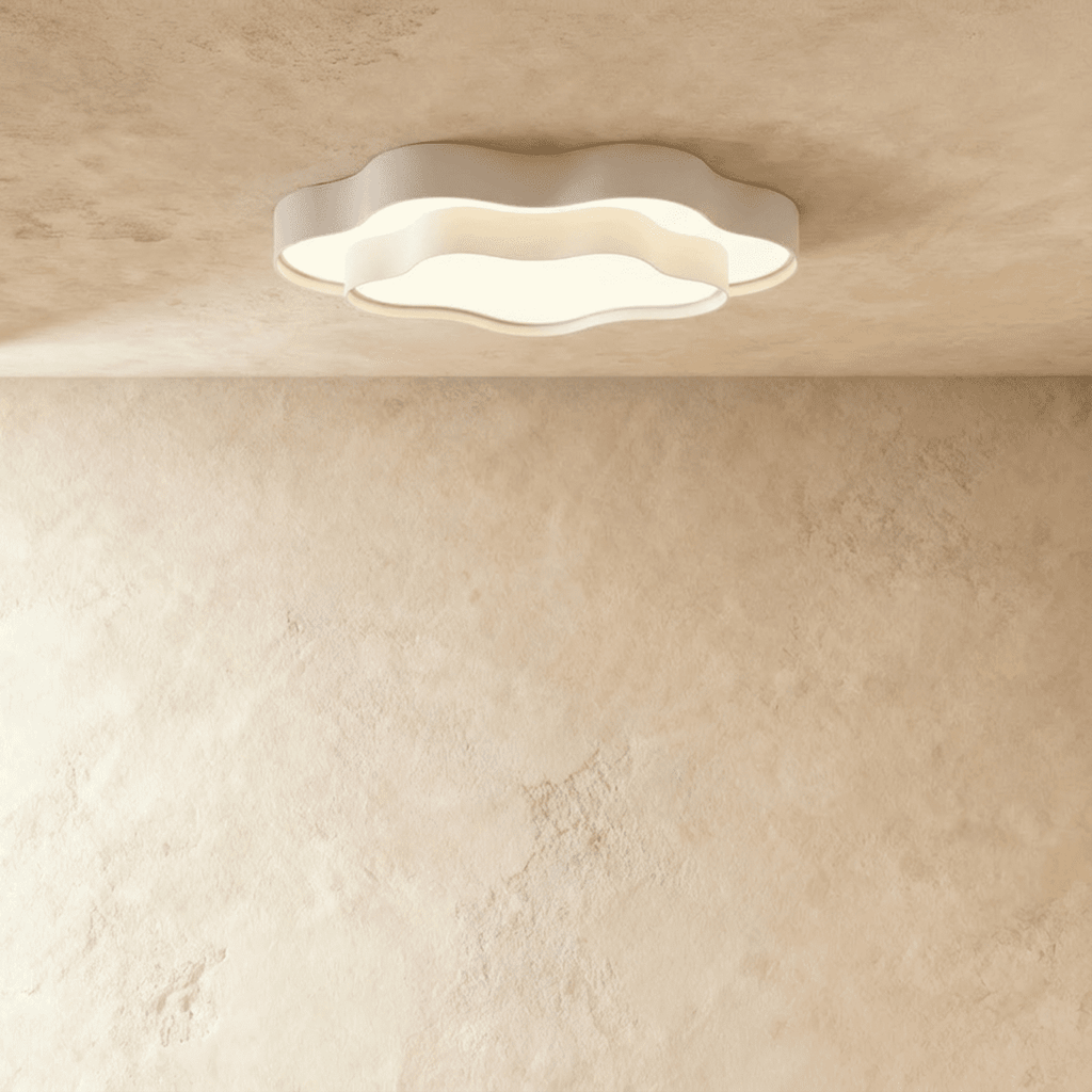 Clérachic flush-mount ceiling light in white iron, two wavy tiers around a glowing frosted diffuser, seen against a limewash wall.