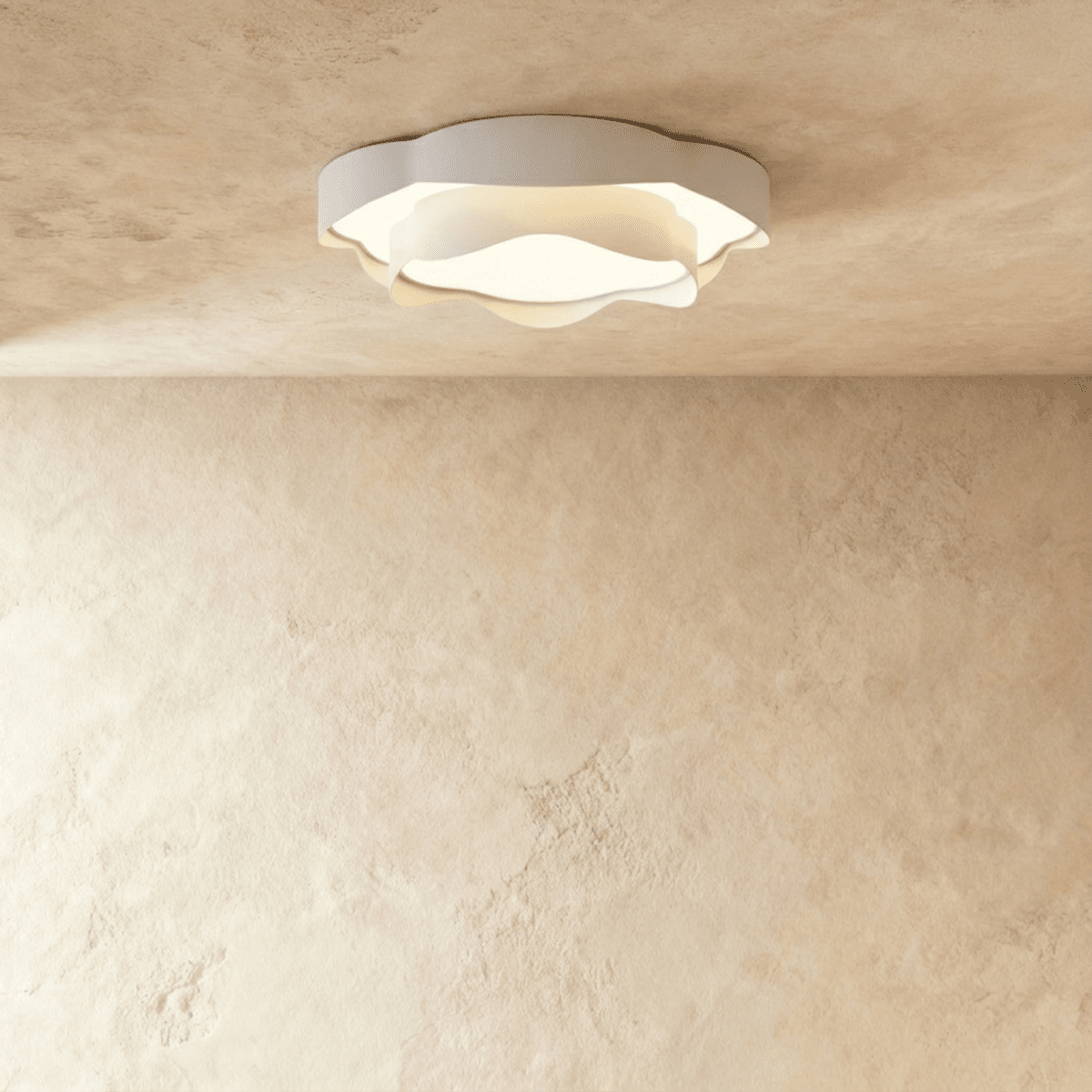 Clérachic round white ceiling light with ruffled petal-like edges and a frosted centre, switched on against a limewash backdrop.