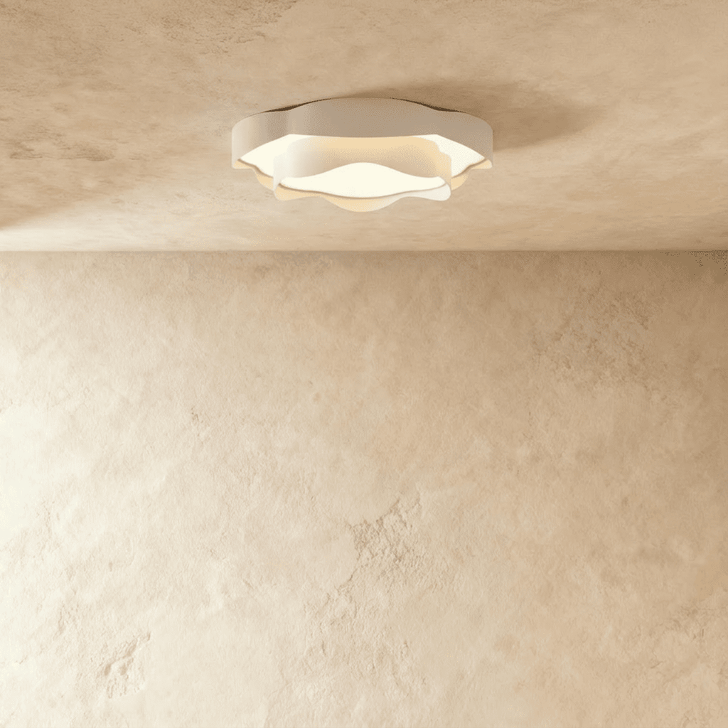 Clérachic compact ruffle-edged white ceiling light with a frosted diffuser, glowing softly on a textured plaster ceiling.