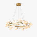 Gold ring Clérachic chandelier on a white backdrop, hung from a round canopy on fine cables, with white ceramic petal shades around the ring.