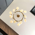 Looking up at the Clérachic ring chandelier from below, with white petal shades circling a gold ring and its round canopy.