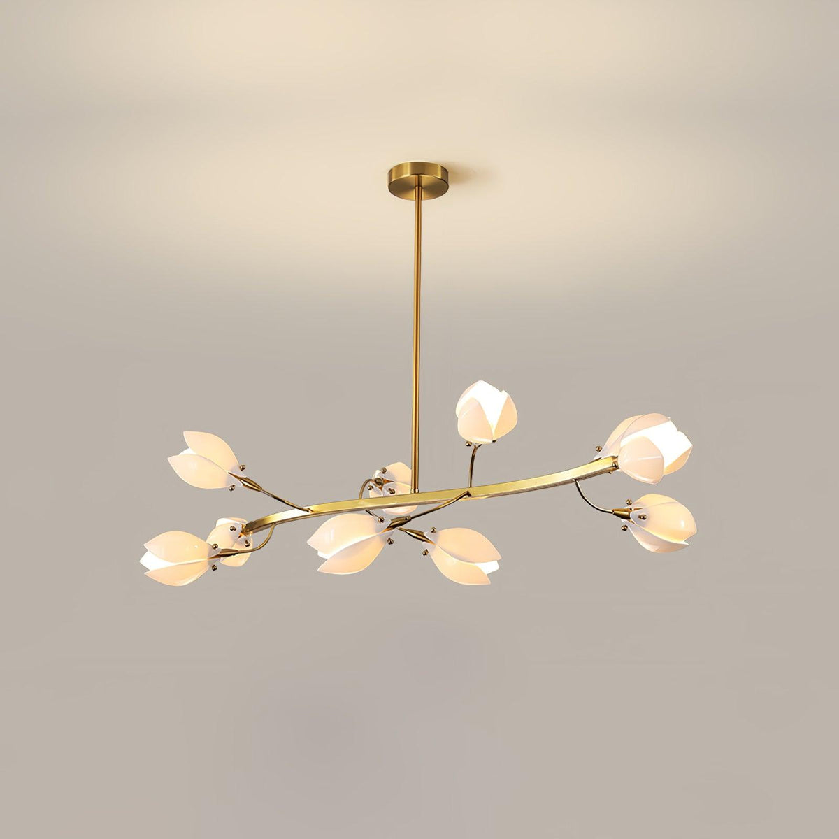A Clérachic chandelier on a gold rod, with a flat curved arm of white petals, lit against a beige wall with a soft light glow above it.