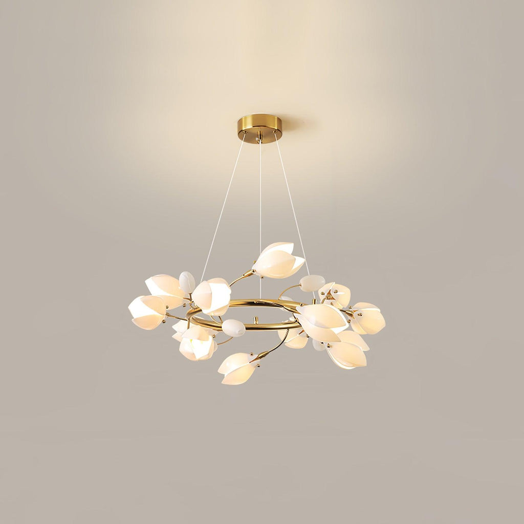 Clérachic ring chandelier lit against a beige wall, hanging on three fine cables from a round gold canopy, with white petal shades.