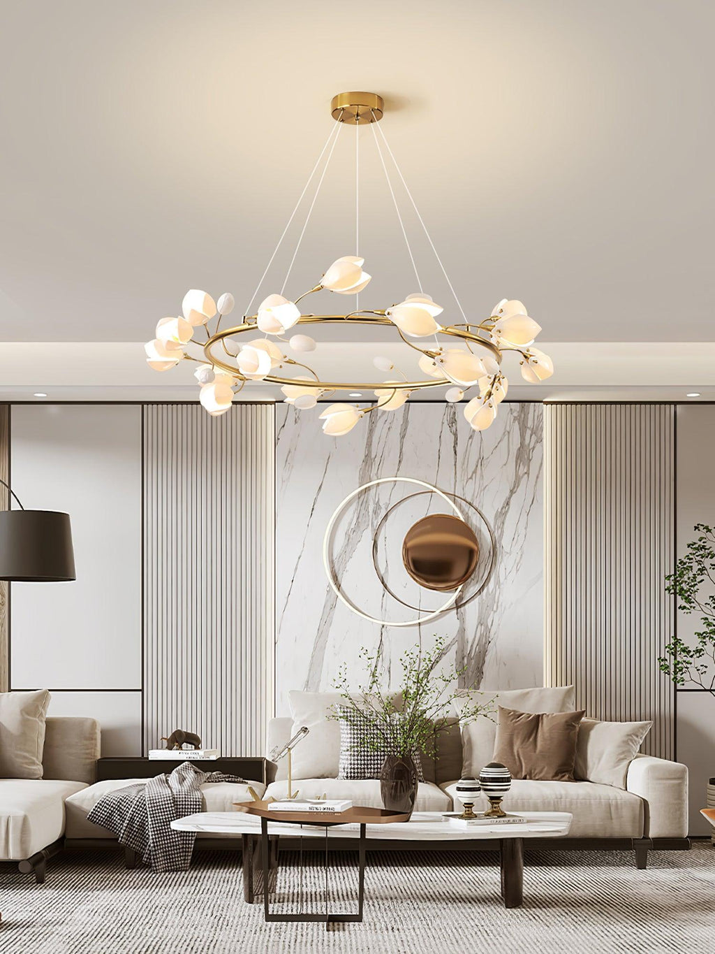 Clérachic chandelier with white petal shades on a gold ring, above a living area with a marble feature wall and a low coffee table.