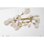 Side view of a Clérachic chandelier with gold coiled branches, white ceramic petals and small buds, on a white backdrop.