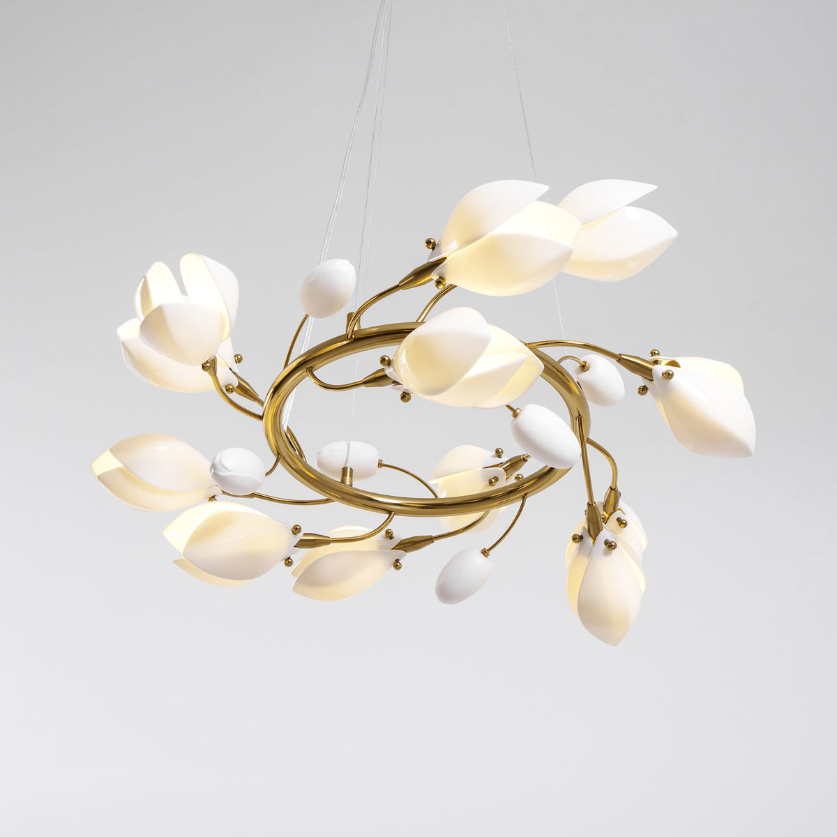 Clérachic chandelier on a grey backdrop, seen from slightly below, with white petals and small bud shades on twisting gold branches.