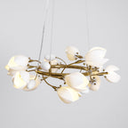 Clérachic chandelier lit on a grey backdrop, hung from two thin cables, with white petals and egg-shaped buds on a gold ring.