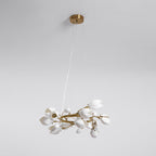 Unlit Clérachic ring chandelier, with a round gold canopy on fine cables and white petal shades on a gold ring, on a grey backdrop.
