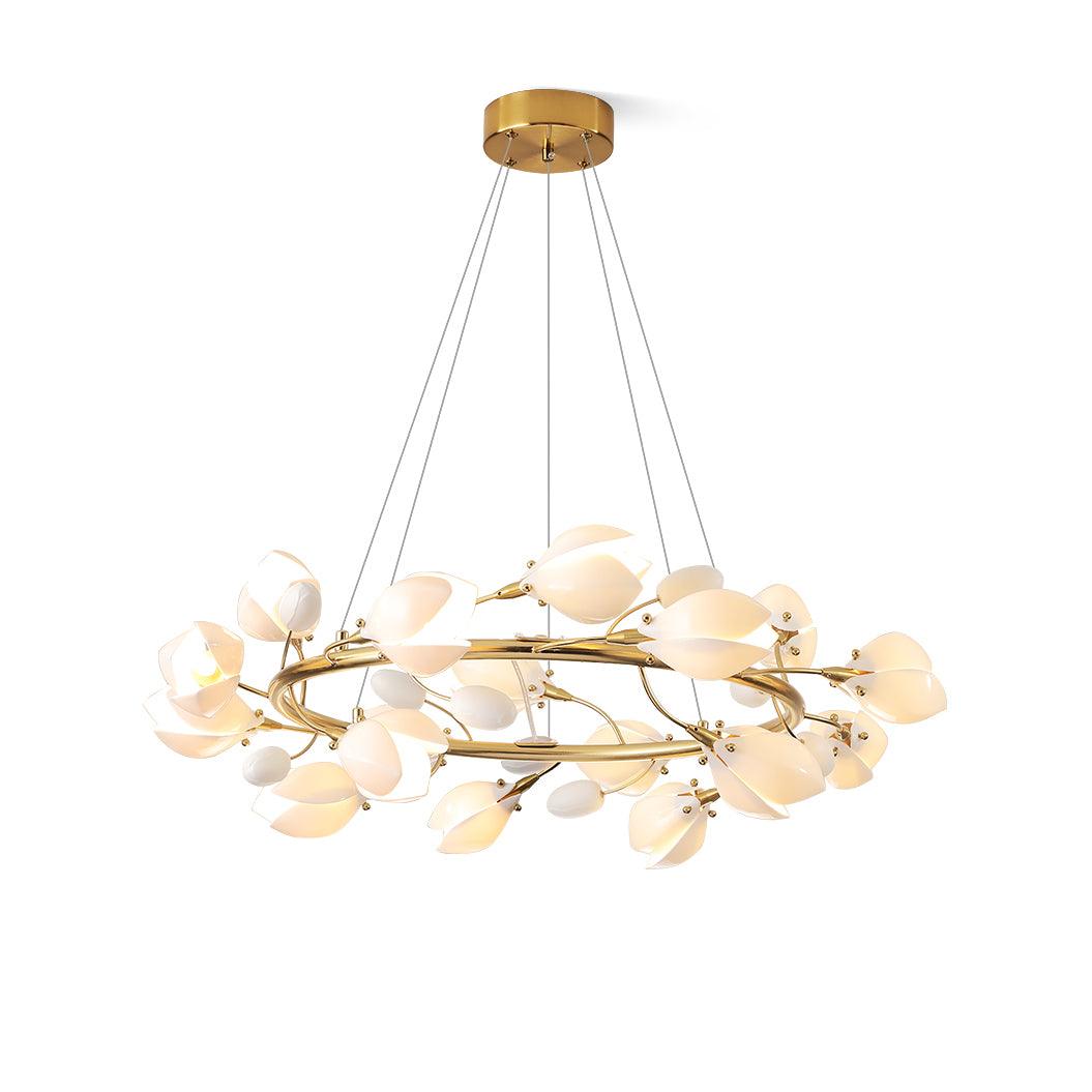 Clérachic ring chandelier lit on a white backdrop, hung from a round gold canopy on three cables, with white petals around the ring.
