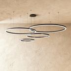 This Clérachic ring chandelier arranges four black loops in a staggered cluster against plaster tones.