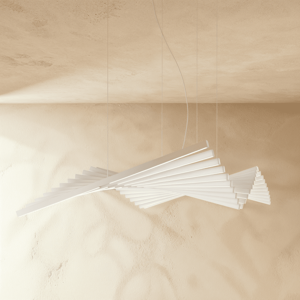 Clérachic's white bar chandelier curves in a sweeping fan shape, lit softly against a warm plaster wall.