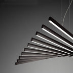 A close view of the Clérachic chandelier shows its dark bars glowing white along their sculptural fan.